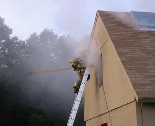 firefighter entering smoking building